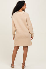 woman wearing a beige maternity sweater dress with a collar, shown from the back
