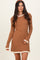 woman wearing a brown ribbed sweater dress with cream ruffle trim details on the neckline and sleeves