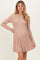 woman wearing a soft pink ribbed maternity dress with long sleeves and a flared skirt, showcasing her baby bump