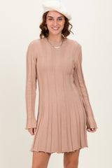 woman wearing a ribbed pink long sleeve dress with a flared hem and a beret