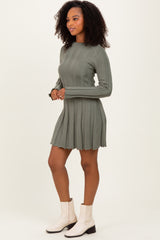 woman wearing a green ribbed long sleeve dress paired with white ankle boots