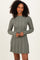 woman wearing a long sleeve ribbed sweater dress in olive green with a flared hemline