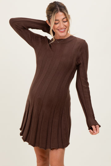woman wearing a brown long sleeve knitted maternity dress with ribbed details and a visible baby bump