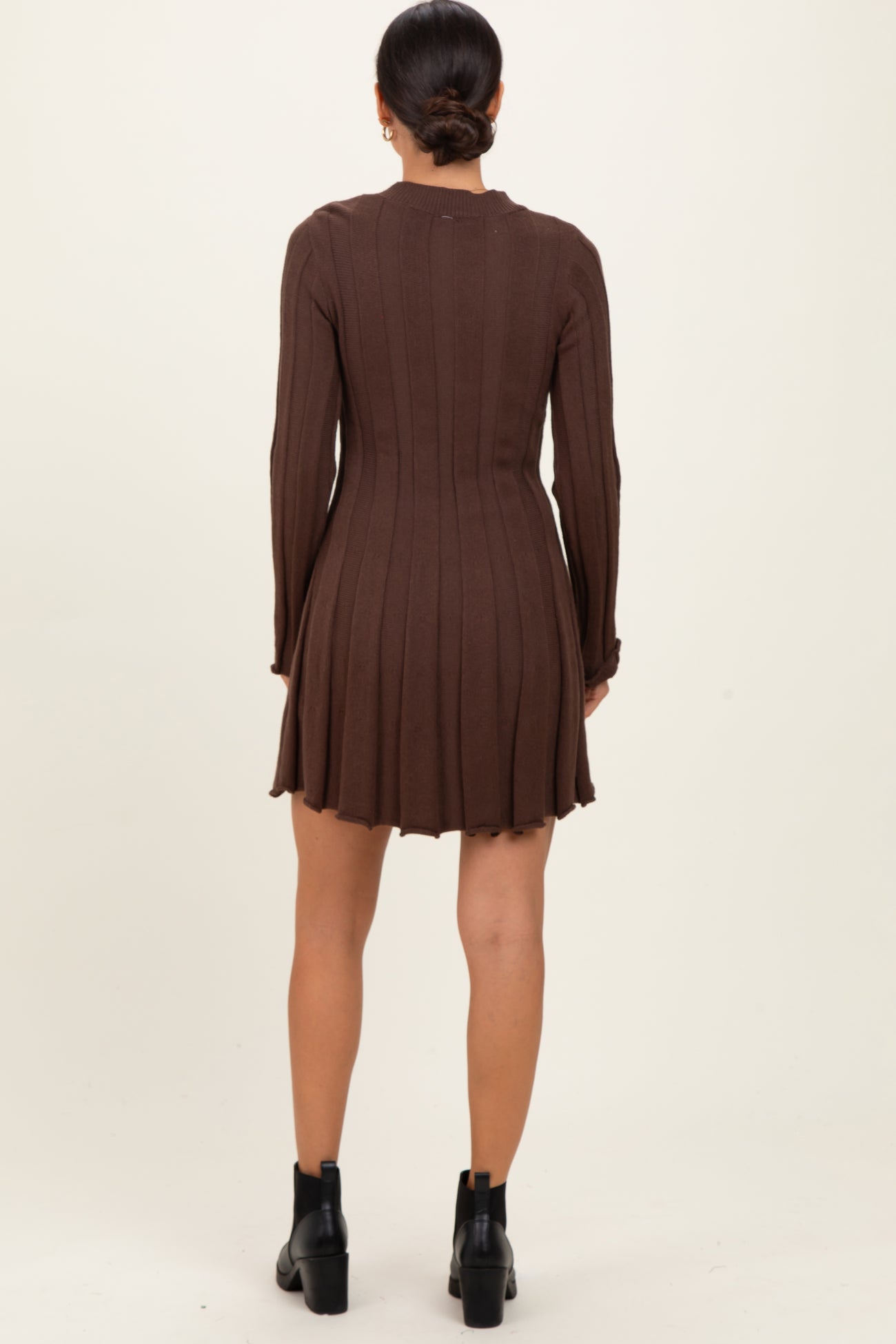 woman wearing a brown ribbed long sleeve dress with a flared hem and back detail