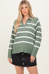 woman wearing a green and white striped long sleeve sweater with a collared neckline and black button-front skirt