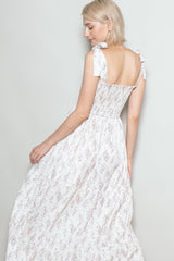 woman wearing a light pink floral maxi dress with tie straps and smocked back detail, photographed from the back