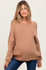 woman wearing a tan off-shoulder maternity sweater with ribbed texture and relaxed fit, showing her baby bump