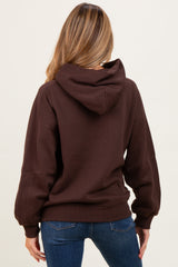woman wearing a brown maternity hoodie with a relaxed fit and a hood, showing the back view