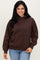 woman wearing a brown hooded sweatshirt with a front pocket and long sleeves, paired with light blue jeans