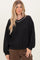 woman wearing a black oversized sweatshirt with a v-neck and contrasting white trim