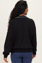 woman wearing a black maternity sweatshirt with a white collar and long sleeves, showing the back view