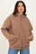 woman wearing a brown quilted zip-up jacket with side pockets and relaxed fit