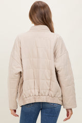 woman wearing a beige quilted maternity jacket with a cinched hem, viewed from the back