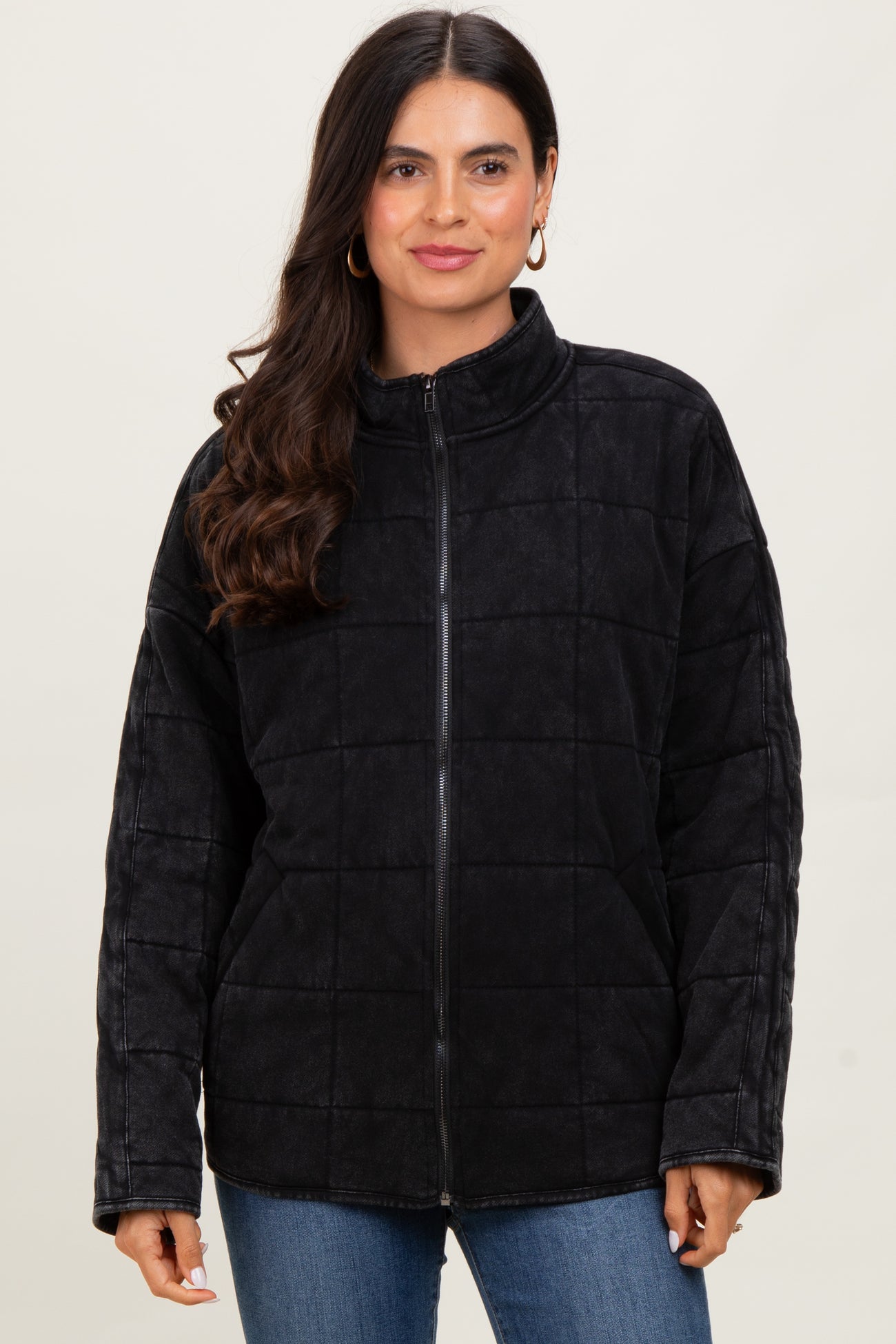 woman wearing a black quilted zip-up jacket with a high collar and long sleeves