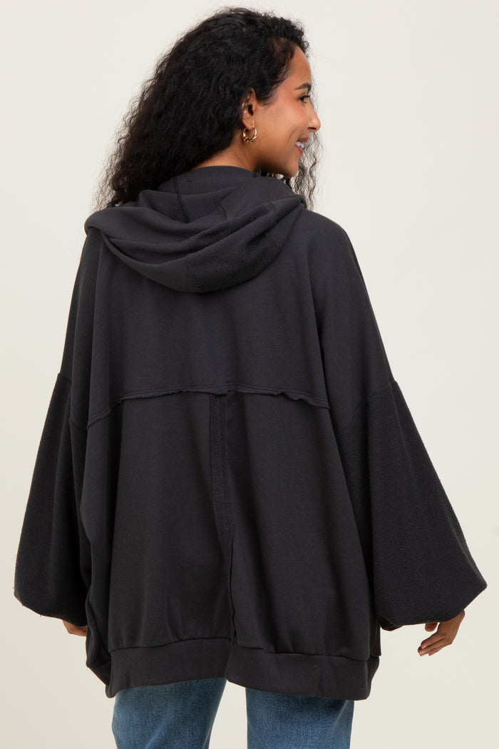 woman wearing a dark gray maternity hoodie with a relaxed fit and wide sleeves, showing off her baby bump from behind