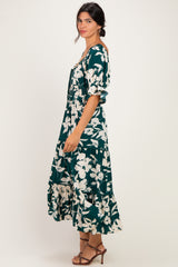 woman wearing a green floral maxi dress with puff sleeves and a tiered hem, standing sideways
