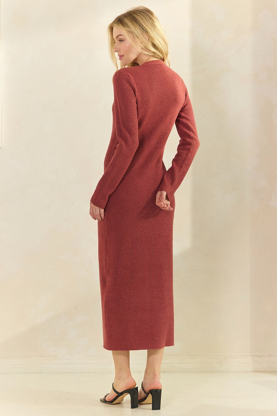 woman wearing a rust long sleeve ribbed midi dress with a fitted silhouette and peek-a-boo back detail