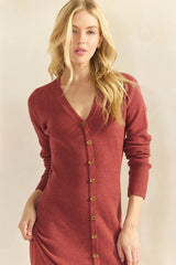 woman wearing a rust-colored ribbed cardigan sweater with a v-neck and button details