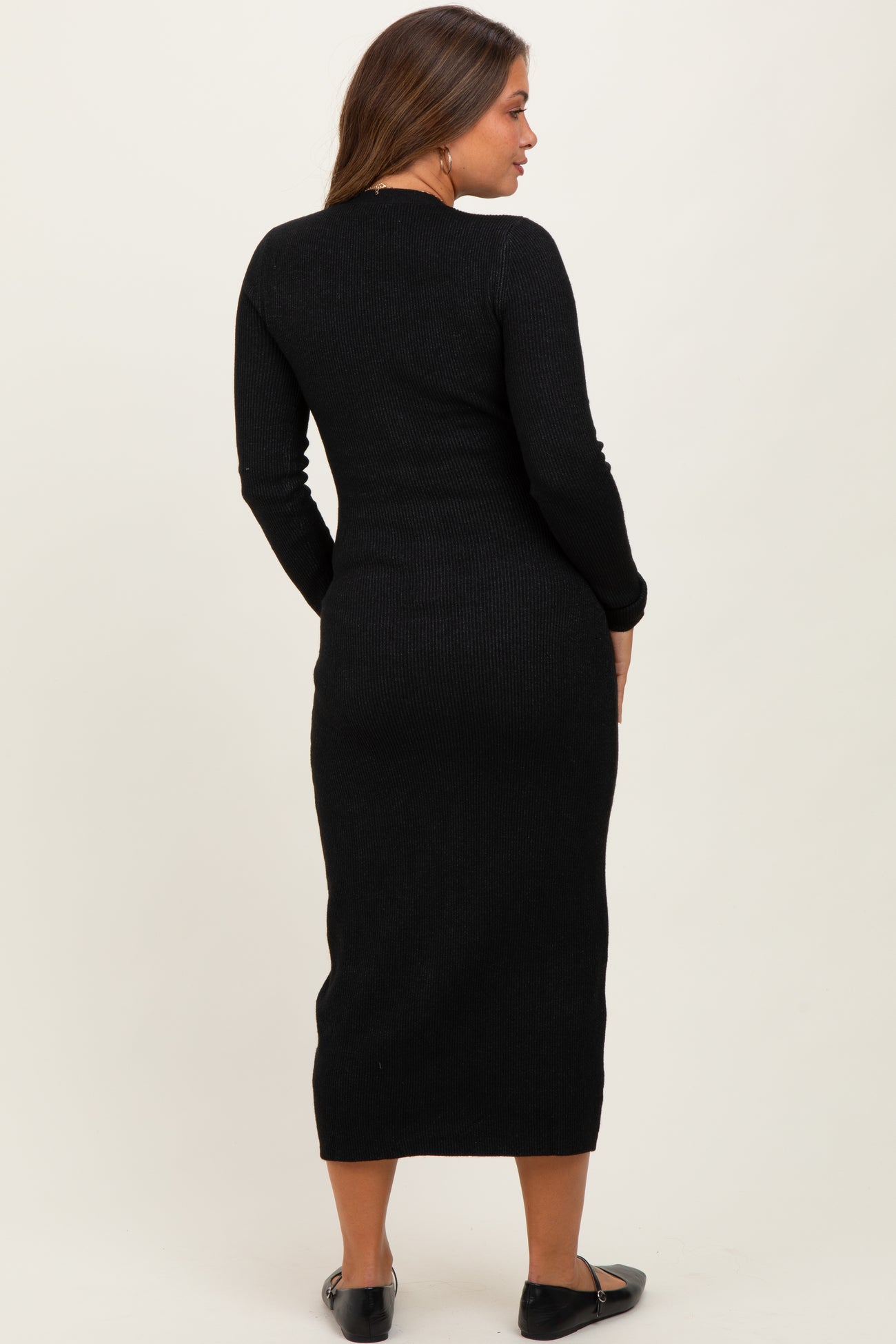 woman wearing a black long sleeve maternity dress, shown from the back, highlighting the fitted silhouette