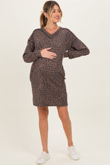 woman wearing a brown animal print maternity dress and holding her baby bump