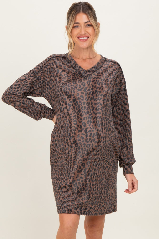 woman wearing a brown and black leopard print maternity dress with a v-neck and long sleeves, showing her baby bump