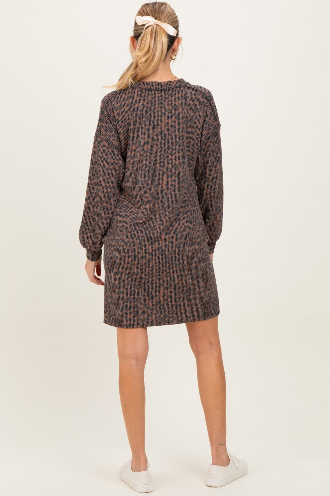woman wearing a brown patterned maternity dress with long sleeves and a loose fit, seen from the back