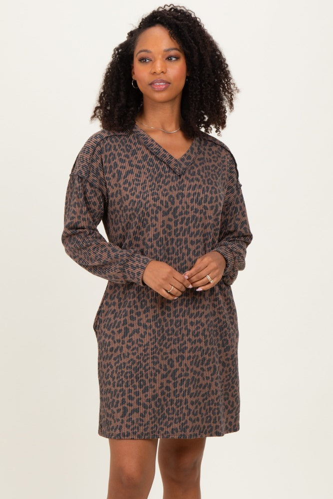 woman wearing a brown and black patterned long sleeve dress with a v-neckline and relaxed fit