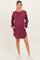 woman wearing a berry striped maternity sweater dress with pockets and long sleeves, standing against a neutral background