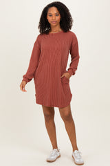 woman wearing a rust striped long sleeve casual dress with pockets and white sneakers