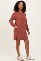 woman wearing a rust-colored long sleeve striped dress with side slits and a relaxed fit