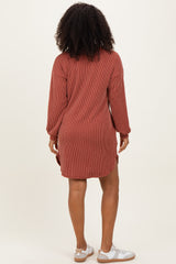 woman wearing a rust striped long sleeve shirt dress with side slits and white sneakers
