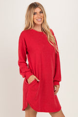 woman wearing a red ribbed long sleeve dress with side pockets and a relaxed fit