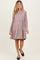 woman wearing a mauve striped long sleeve maternity dress with a tiered skirt and a visible baby bump