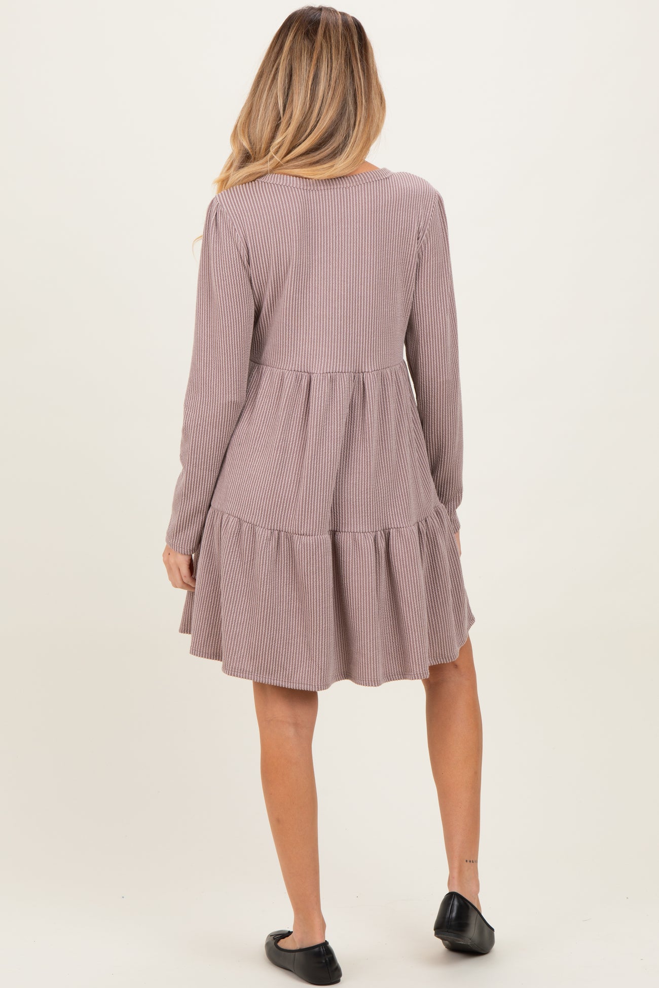 woman wearing a striped long sleeve maternity dress with a tiered skirt and ruched back design