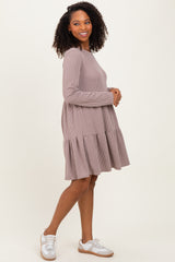 woman wearing a taupe ribbed long sleeve dress with a tiered skirt and white sneakers