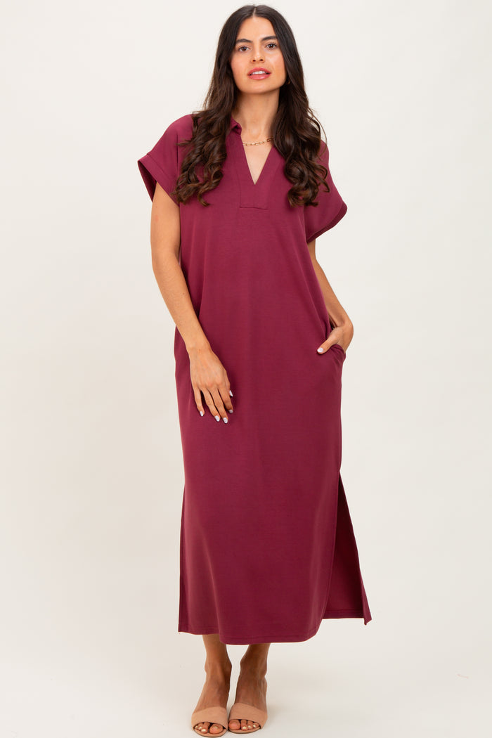 woman wearing a burgundy short sleeve maxi dress with a v-neck and side pockets