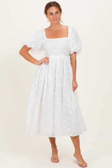 woman wearing a white floral midi dress with puff sleeves and a square neckline