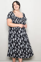 woman wearing a black floral plus size midi dress with puff sleeves and a square neckline
