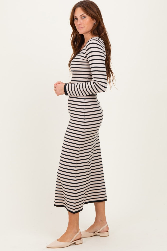woman wearing a long sleeve striped maxi dress in black and cream, standing sideways with a relaxed fit