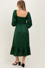woman wearing a green puff sleeve midi dress with smocked bodice and ruffle hem, shown from the back