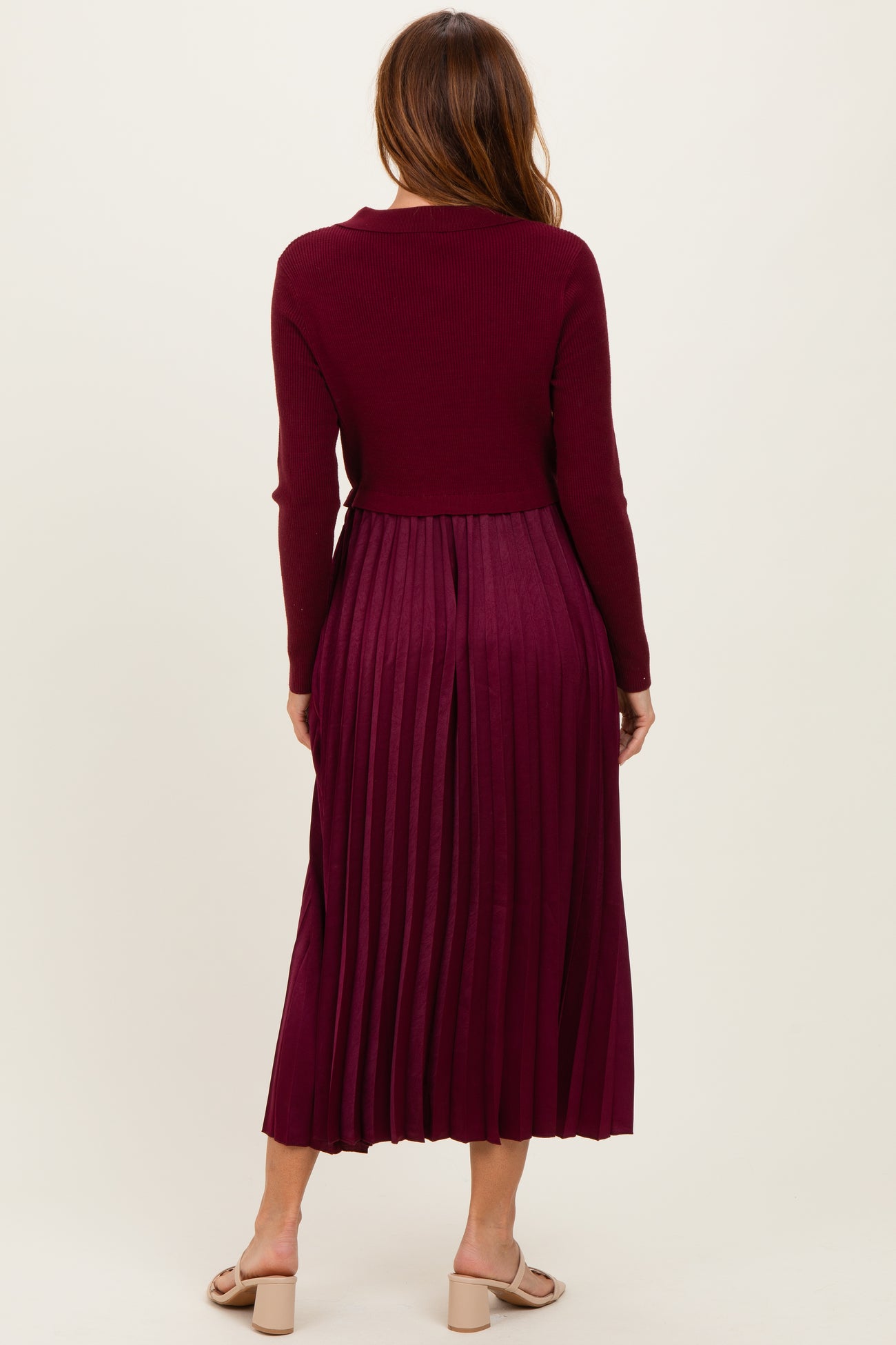 woman wearing a burgundy ribbed long sleeve dress with pleated skirt and back view shown