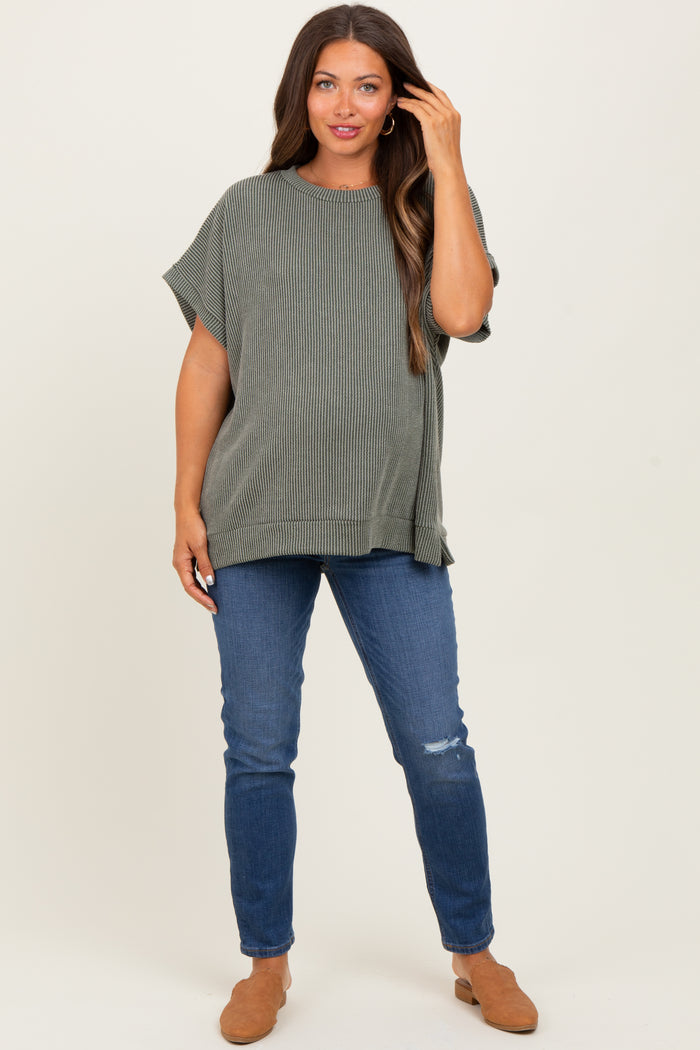 woman wearing a striped green maternity top with short sleeves and blue distressed jeans
