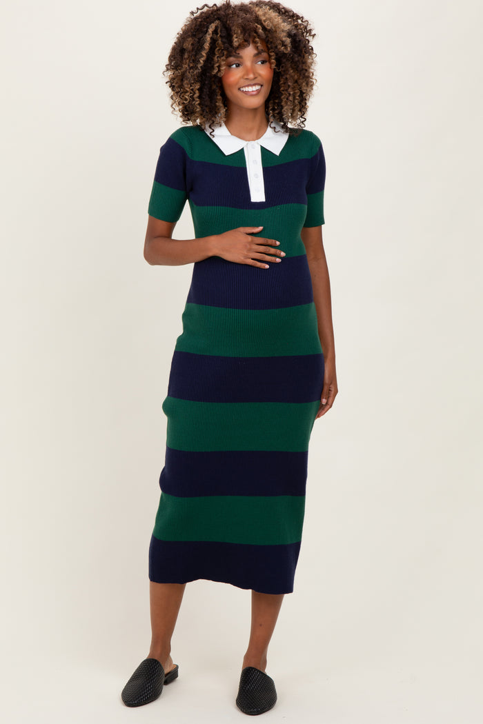 woman wearing a navy and green striped maternity dress with a white collar and holding her baby bump