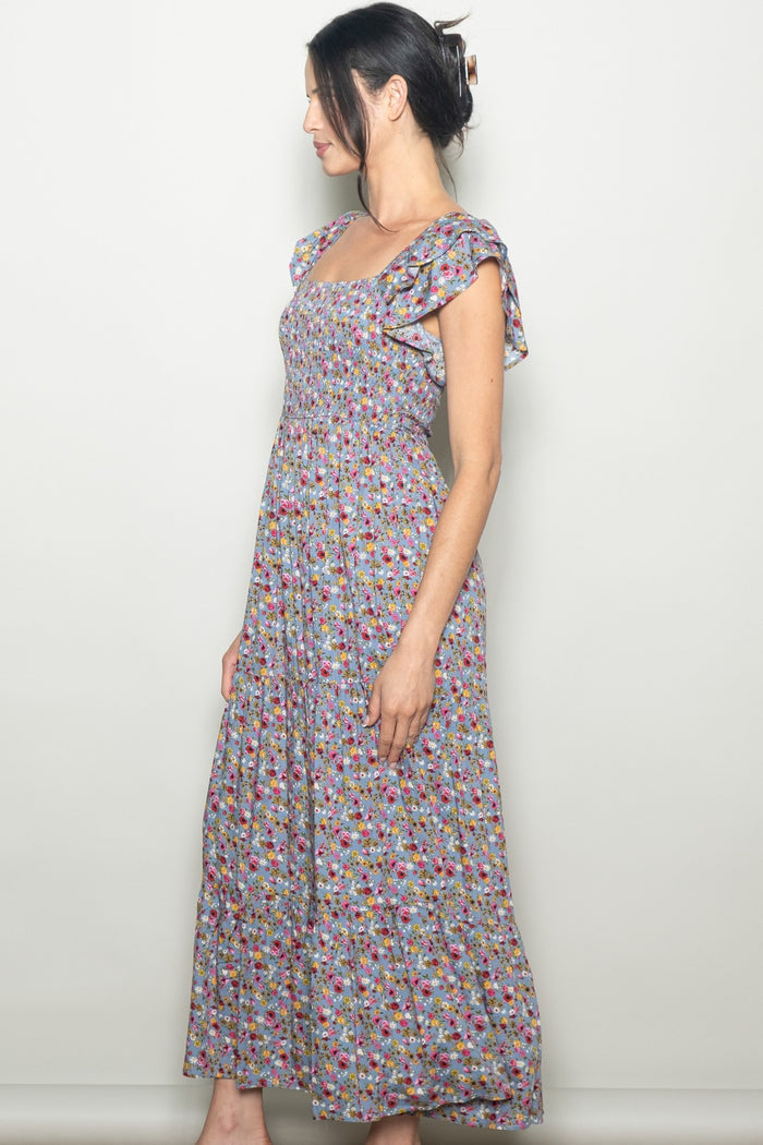 woman wearing a sleeveless floral maxi dress with ruffle sleeves and a fitted bodice