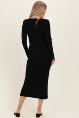 woman wearing a black ribbed midi dress with long sleeves and white trim details, viewed from the back