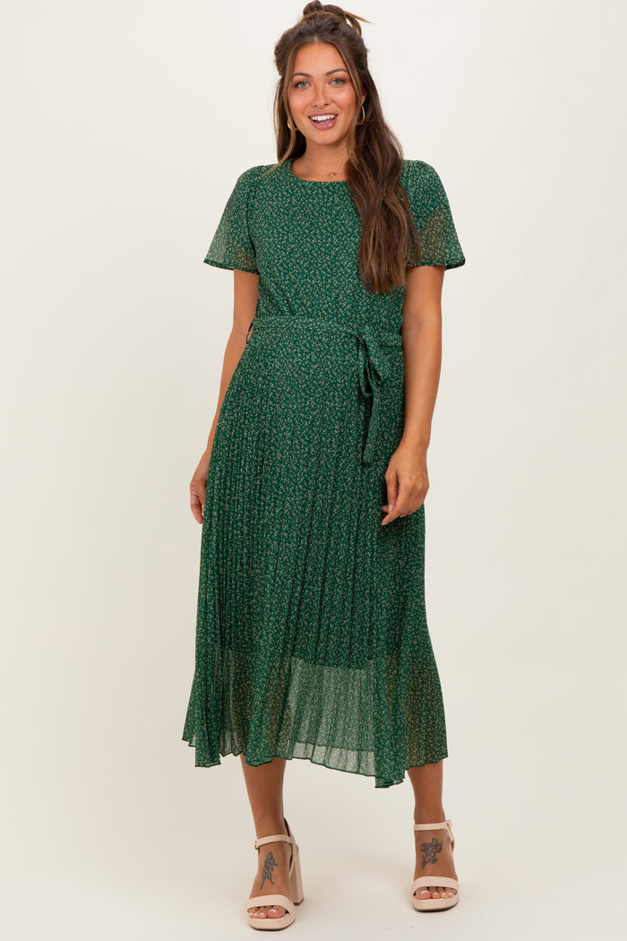 woman wearing a green floral maternity dress with short sleeves and a tied waist detail