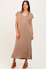 woman wearing a brown maxi dress with a white collared neckline and side slits, standing and smiling