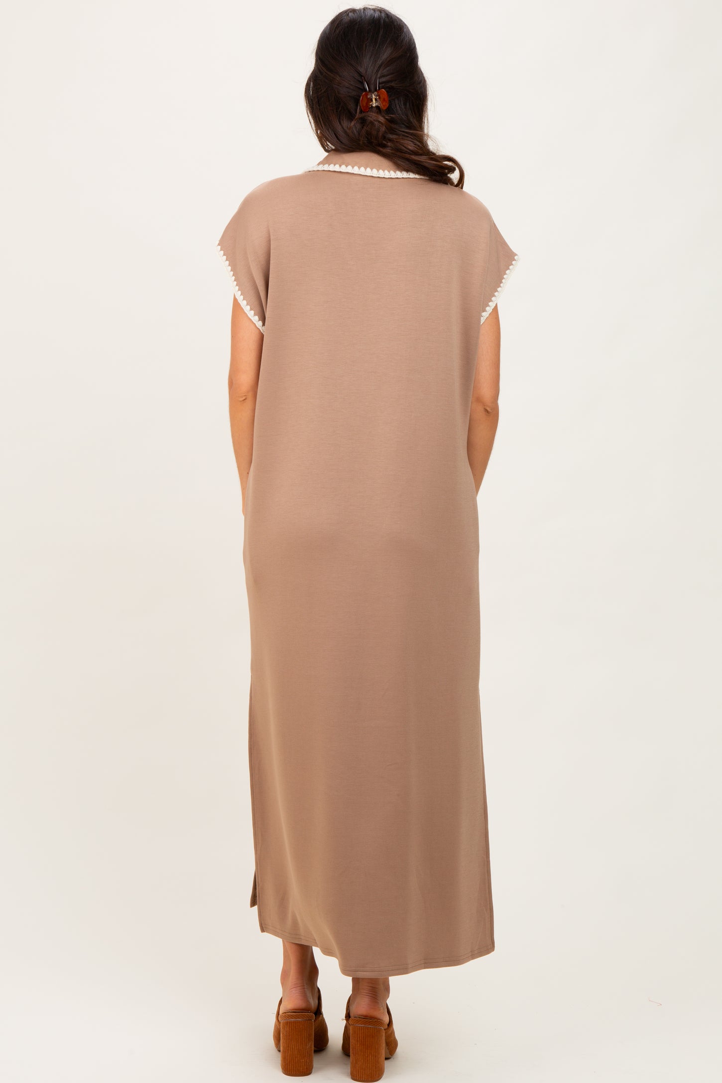 woman wearing a long brown maxi dress with short sleeves and a delicate lace trim on the neckline
