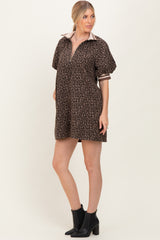 woman wearing a brown leopard print polo dress with short sleeves and a zippered collar, paired with black ankle boots