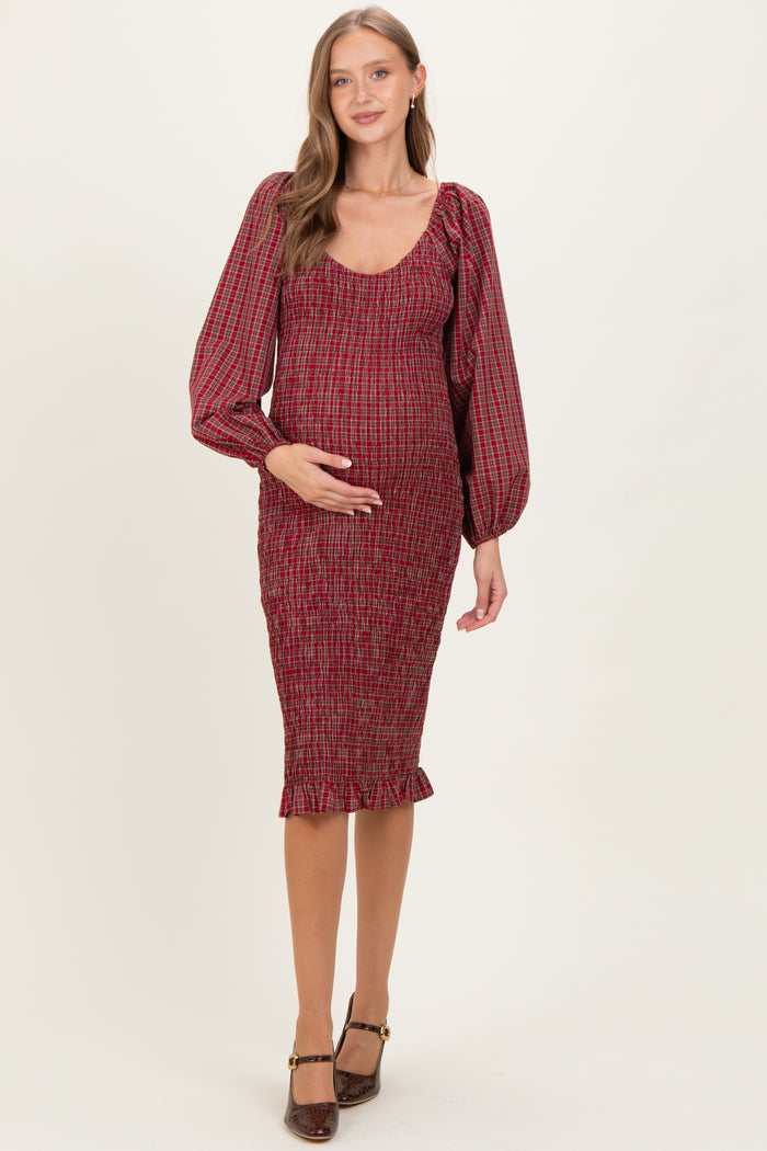 woman wearing a red checkered maternity dress with puffed sleeves and a fitted silhouette, highlighting her baby bump